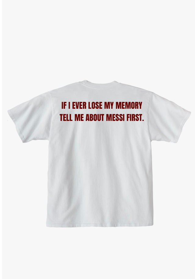 A white short-sleeve t-shirt shown from the back, featuring the humorous text 'IF I EVER LOSE MY MEMORY TELL ME ABOUT MESSI FIRST.' printed in a dark red serif font across the upper back.